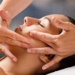 Close up portrait of woman having facial cosmetic therapy. Therapist applying cream on female cheek.